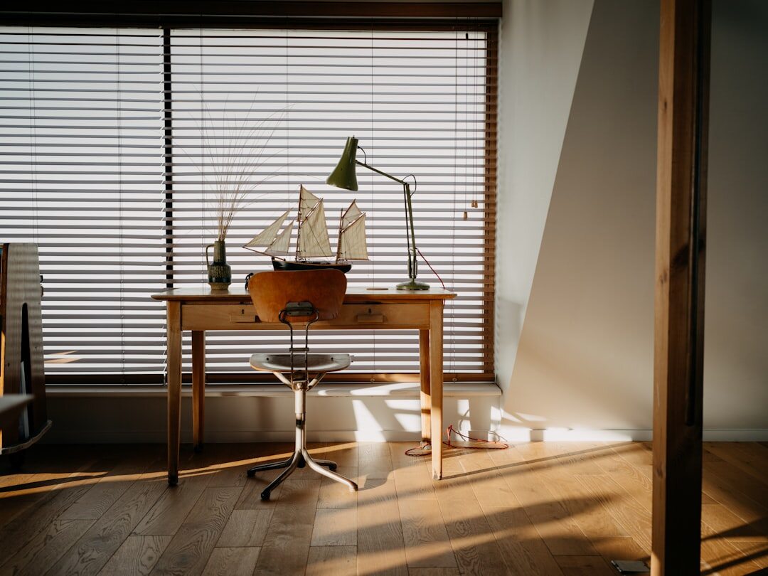 Open notebook and pen on a wooden desk near a window