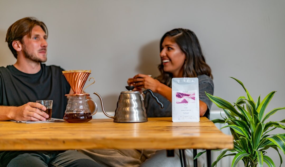 Two people having a calm, attentive conversation over coffee